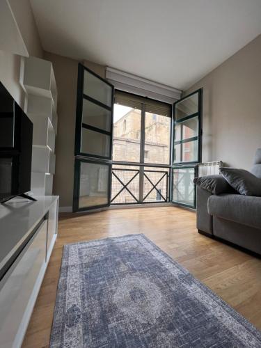 a living room with a couch and a large window at Apartamento Elena Tour in Logroño
