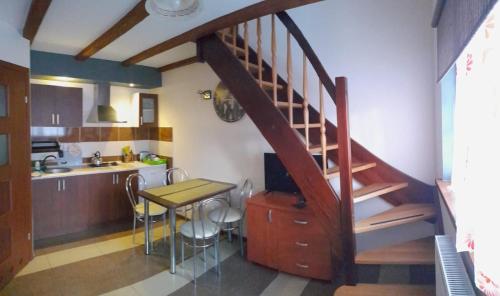 uma cozinha com uma escada e uma mesa numa cozinha em Apartamenty rodzinne U Zośki em Łukęcin