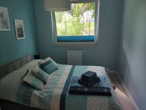 una camera da letto con un letto con una coperta e una finestra di Przytulny apartament z ogródkiem a Cracovia