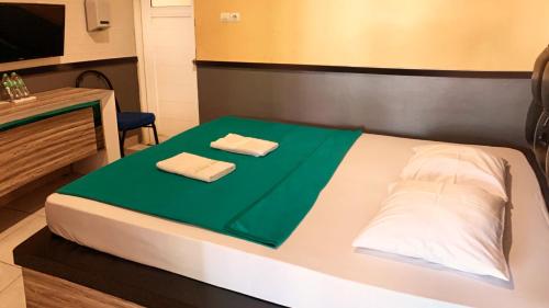 a bed with two towels sitting on top of it at Omah Pelem Syariah in Semarang