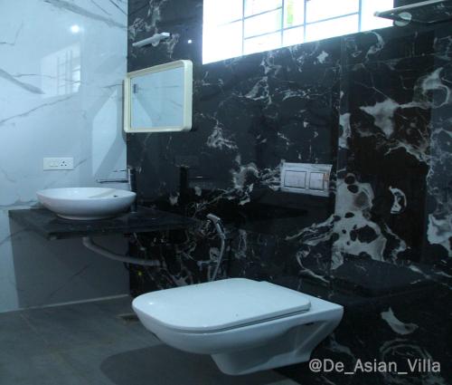 a bathroom with a toilet and a sink at De Asian Villa Pondicherry in Auroville
