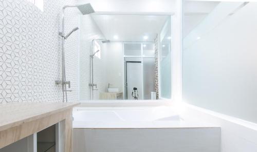 Baño blanco con lavabo y espejo en RedDoorz at DBuilders Rooms Lower Bicutan en Manila