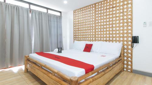 1 dormitorio con 1 cama con cabecero de madera en RedDoorz at DBuilders Rooms Lower Bicutan en Manila