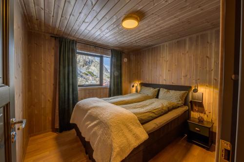 una camera con un letto in una stanza con una finestra di Superior Cabin Ballstad Lofoten a Ballstad