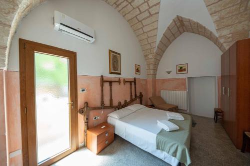 a bedroom with a bed and a large window at B&B Palazzo la Traja in Gagliano del Capo