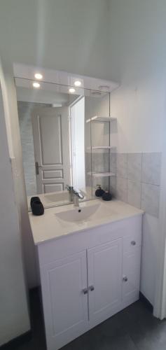 une salle de bain blanche avec un lavabo et un miroir dans l'établissement Le Tréport vue sur mer et sur l entrée du port, au Tréport