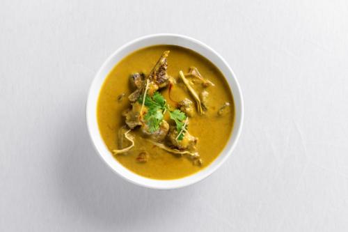 a white bowl of soup on a white table at Sarasiruham Resort - Private Pool Villa in Udaipur in Udaipur