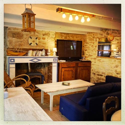 un salon avec une table et une cheminée dans l'établissement Authentique maison de pêcheur au coeur d'un hameau, à Crozon