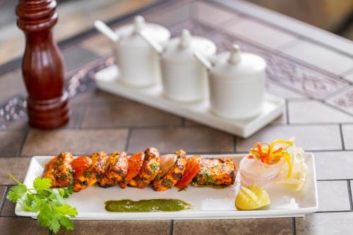 a plate of food with meat and vegetables on a table at Sarasiruham Resort - Private Pool Villa in Udaipur in Udaipur