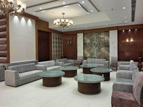 a waiting room with couches and tables and a chandelier at Hotel Sakura by Maps in Gurgaon