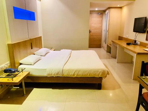 a bedroom with a bed and a television in it at Hotel Rama Krishna in Lonavala