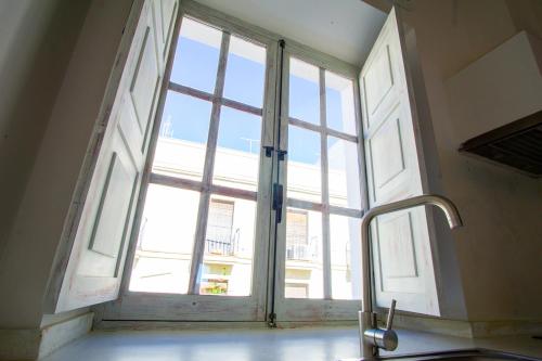 a large window in a room with a sink and a sink at Apartamentos Sharis in Jerez de la Frontera