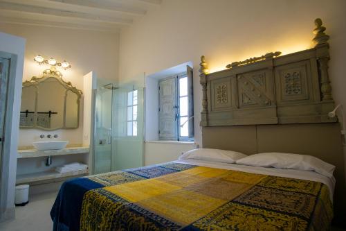 a bedroom with a bed and a bathroom with a sink at Apartamentos Sharis in Jerez de la Frontera