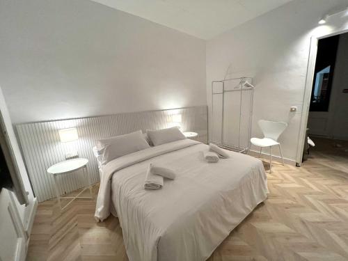 biała sypialnia z dużym łóżkiem i 2 krzesłami w obiekcie The MO GOTIC w Barcelonie