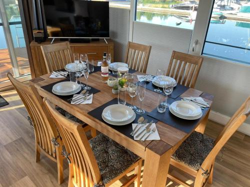 una mesa de madera con platos y copas de vino. en Hausboot Vroni am Bärwaldersee en Klitten