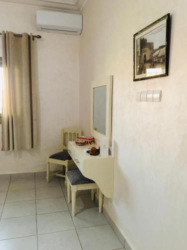 a bathroom with a sink and a mirror and a chair at Riad Nasma Souihla in Marrakech