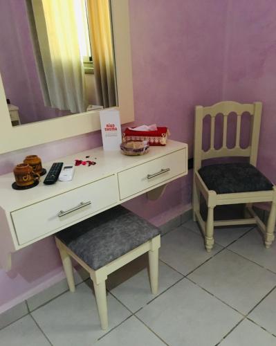 a dressing table with a chair and a mirror at Riad Nasma Souihla in Marrakech