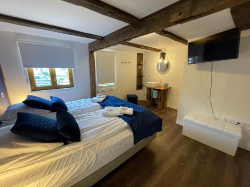 1 dormitorio con 1 cama grande con almohadas azules en Bi d'Grosseltere Gîtes de charme, en Kirrwiller