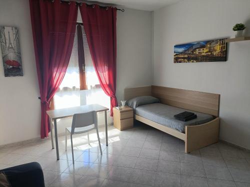 Schlafzimmer mit einem Bett, einem Tisch und einem Fenster in der Unterkunft Sofia Sweet Home in Corsico