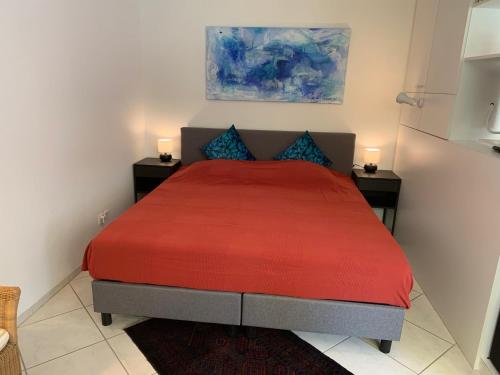 ein Schlafzimmer mit einem roten Bett mit zwei Nachttischen in der Unterkunft Apartment Flims Waldhaus - Surselvapark A4 in Flims