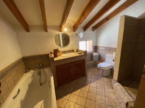 a bathroom with a tub and a sink and a toilet at CAN LLUNA Tú casa zen in Tárbena