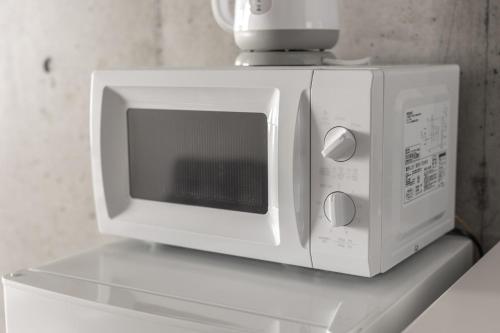 a white microwave sitting on top of a shelf at Marvelous Koiwa - Vacation STAY 90651v in Tokyo