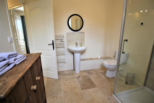 a bathroom with a sink and a toilet and a mirror at Joli gîte pour 5 personnes : Chez Cherrie in Saint-Julien-de-Lampon