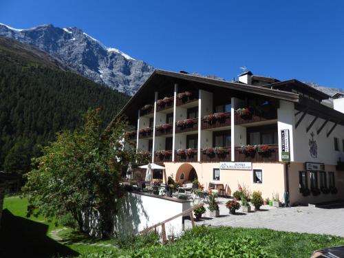 a hotel in the mountains with mountains in the background at Alpina Mountain Resort in Solda