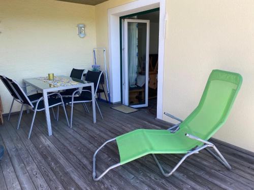 a green chair and a table in a room at Haus Lechner Apartments in Sankt Jakob in Haus