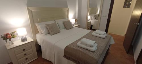 um quarto com uma cama grande com duas almofadas em Dúplex Mirador del Guadiana em Ayamonte