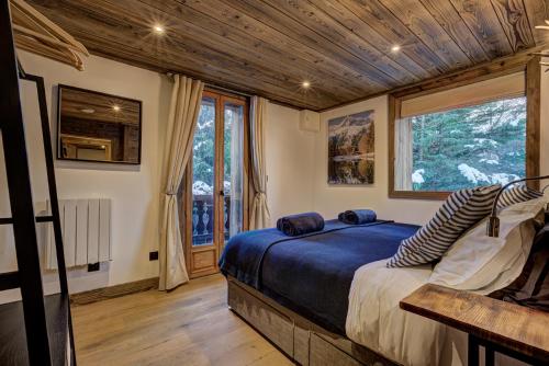 Un dormitorio con una cama y una ventana grande. en Chalet Chèvrefeuille, en Saint-Gervais-les-Bains