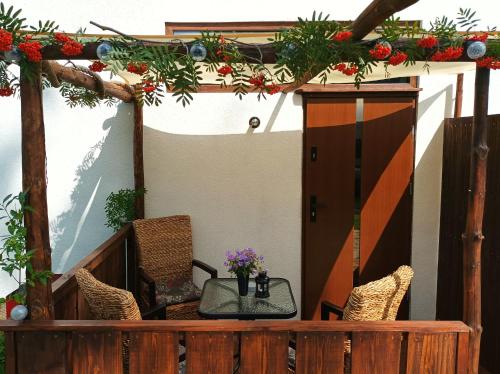 - une terrasse couverte avec une table, des chaises et des fleurs dans l'établissement Zdomek, à Teplice