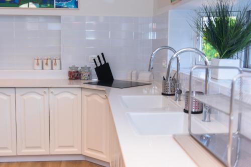 a kitchen with white cabinets and a sink at Villa Ono - at Bar Ilan University and Sheba Hospital in Qiryat Ono