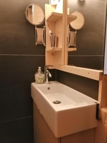 une salle de bain avec un lavabo blanc et un miroir dans l'établissement Appartement de 28 m2, centre station les 2 alpes, à Les Deux Alpes