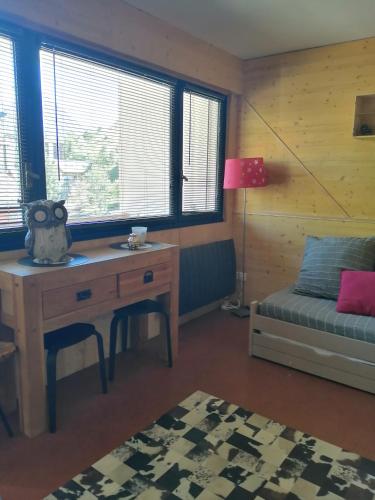 Cette chambre comprend un bureau, un canapé et une table. dans l'établissement Appartement de 28 m2, centre station les 2 alpes, à Les Deux Alpes