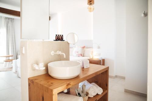 a bathroom with a sink on a wooden table at Hotel Boutique & Spa Las Mimosas Ibiza in San Antonio Bay