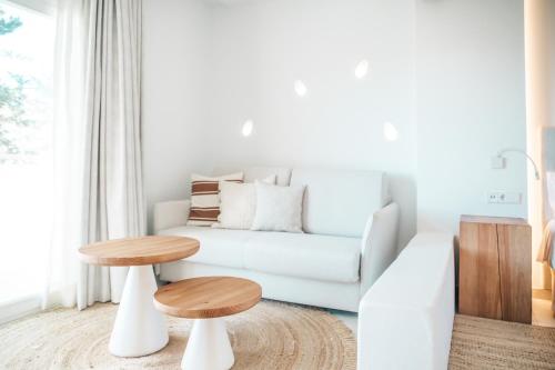 a living room with a white couch and a table at Hotel Boutique & Spa Las Mimosas Ibiza in San Antonio Bay