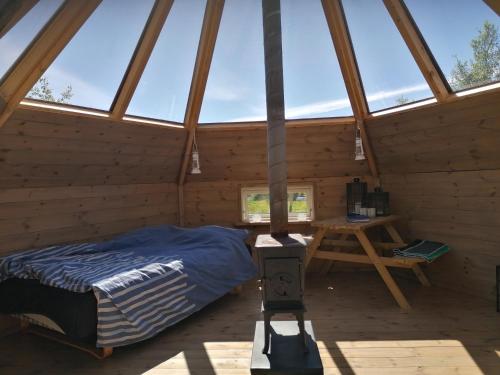ein Schlafzimmer in einer Holzhütte mit einem Bett und einem Tisch in der Unterkunft Hessdalen Ufocamp in Vårhus