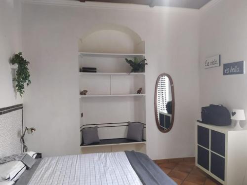 - une chambre blanche avec un lit et un miroir dans l'établissement Testaccio alloggio turistico, à Rome