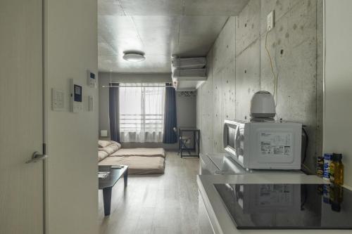 een woonkamer met een magnetron en een bank bij Marvelous Koiwa - Vacation STAY 90666v in Tokyo
