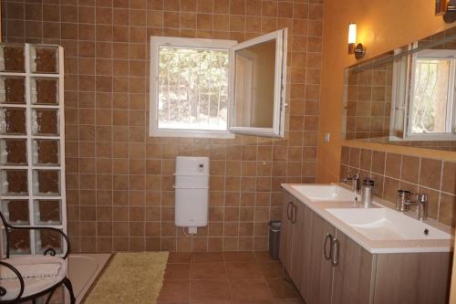 a bathroom with a sink and a toilet and a window at VILLA 4pers, STUNNING SEA VIEW, BEACH ON FOOT 4* in Olmeto