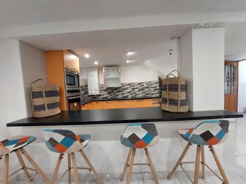 a kitchen with three bar stools and a counter at Happy Land Holliday residential in Épinay-sur-Seine