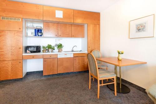 a small room with a table and a kitchen at acora Leipzig Living the City in Leipzig