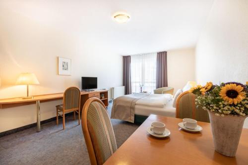 una camera d'albergo con letto e tavolo di acora Leipzig Living the City a Lipsia