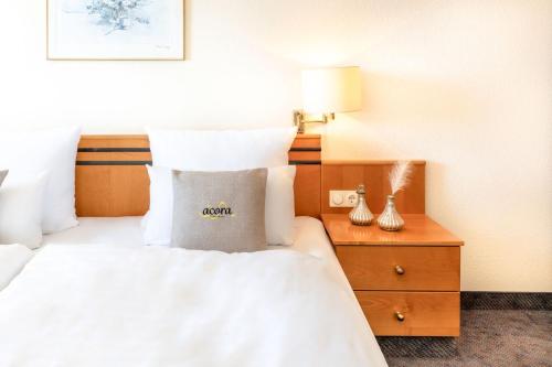a hotel room with a bed with a pillow on it at acora Leipzig Living the City in Leipzig