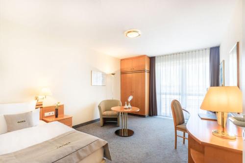 a hotel room with a bed and a table and chairs at acora Leipzig Living the City in Leipzig