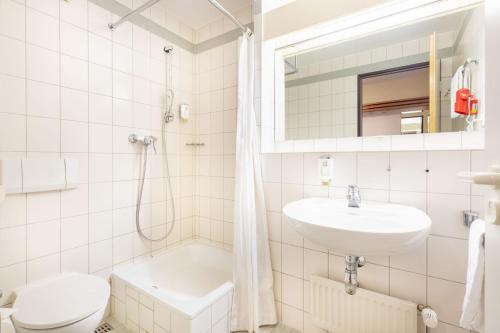 ein Bad mit einem Waschbecken, einem WC und einer Dusche in der Unterkunft acora Leipzig Living the City in Leipzig