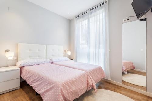 バレンシアにあるConde de Melito Apartmentの白いベッドルーム(ピンクベッド1台、鏡付)