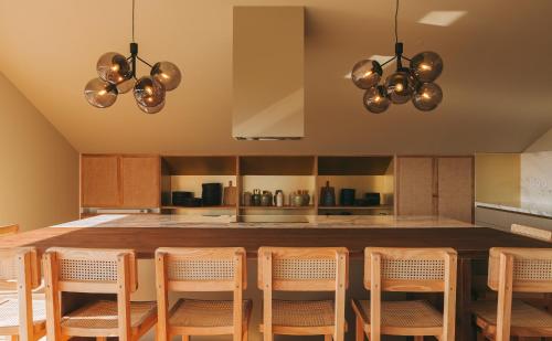 a kitchen with a large island with chairs and lights at Village Aparthotel By BOA in Porto