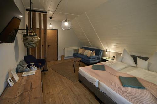 a bedroom with a bed and a living room at Zöld Béka Vendégház in Komló